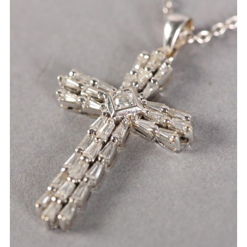 253 - A DIAMOND SET CROSS SET with tapered baggett cut stones with a single brilliant cut stone to the cen... 