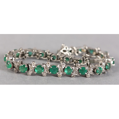 255 - AN EMERALD AND DIAMOND BRACELET, the circular faceted emeralds claw set in line, interspersed with a... 