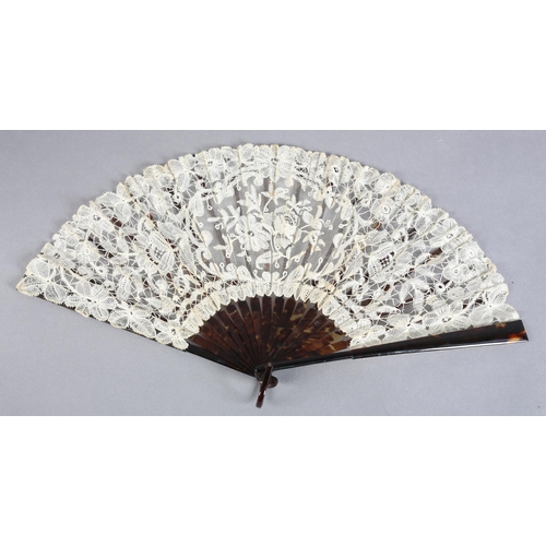 27 - A c 1910 Brussels mixed lace fan, the monture of tortoiseshell, well mottled, the ribs the same, the... 