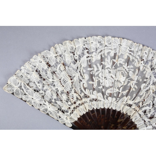 27 - A c 1910 Brussels mixed lace fan, the monture of tortoiseshell, well mottled, the ribs the same, the... 