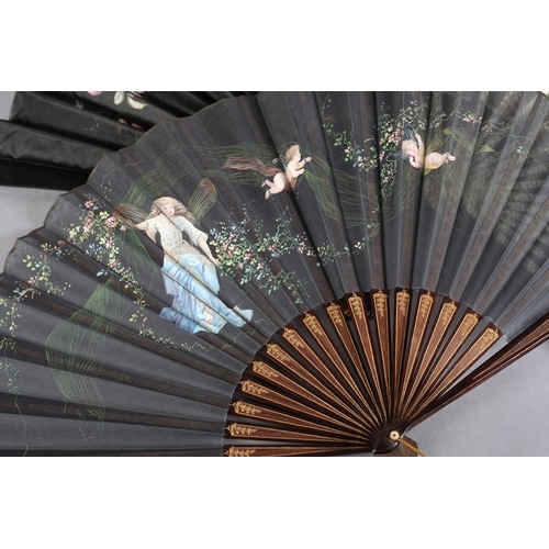 31 - Seven large late 19th century folding fans: an elegant wood fan, the monture gilded, the strong blac... 