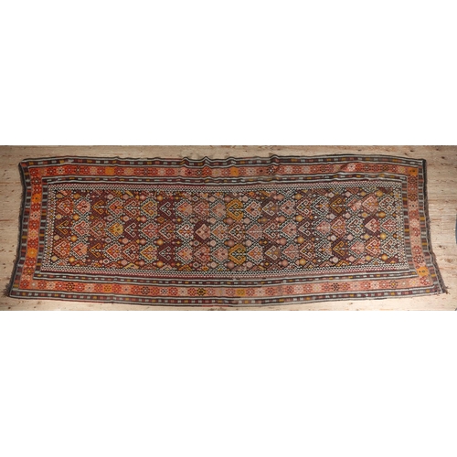 310 - A KELIM RUNNER worked in yellow, aubergine, mauve, wine, brown and ochre with a traditional geometri... 