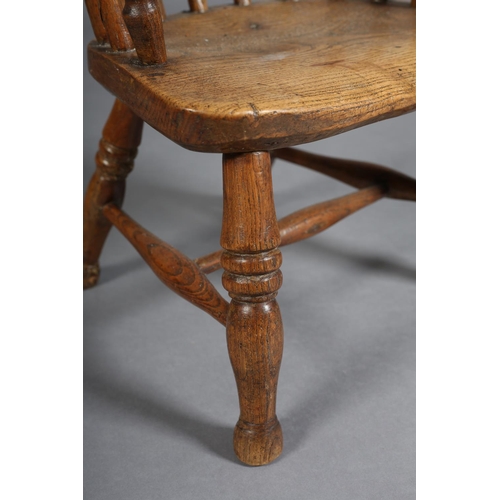 384 - A 19TH CENTURY CHILD'S ELM AND ASH WINDSOR CHAIR having a rail back, on turned legs and rounded stre... 