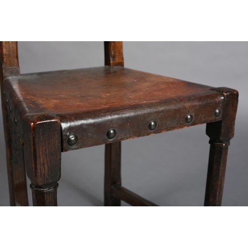 386 - A LATE 19TH CENTURY ELM HALL CHAIR, the panel back pierced with diamond and triform motifs, gauge-cu... 