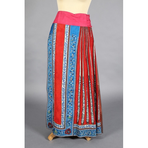 62 - A red Chinese silk skirt, Qing Dynasty, unusually long, cotton waistband, applied with vertical pane... 