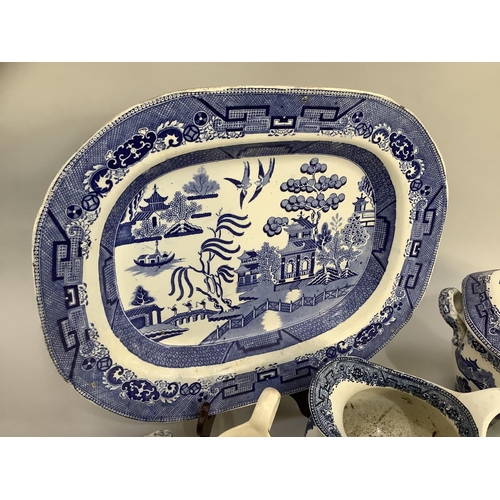 105 - A collection of Victorian and later blue and white willow pattern dinner ware of differing factories... 