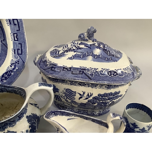 105 - A collection of Victorian and later blue and white willow pattern dinner ware of differing factories... 