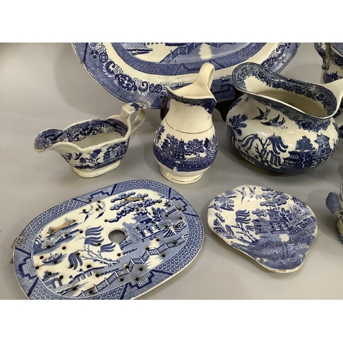 105 - A collection of Victorian and later blue and white willow pattern dinner ware of differing factories... 