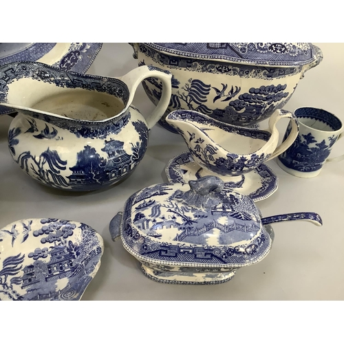 105 - A collection of Victorian and later blue and white willow pattern dinner ware of differing factories... 