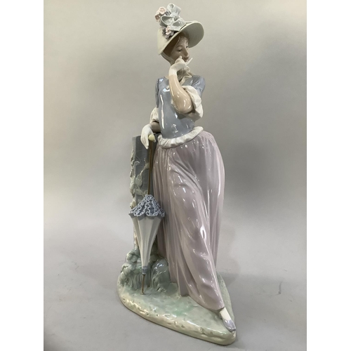 25 - A large Lladro figure of a young woman with a flower and ribboned bonnet and parasol, in pensive moo... 