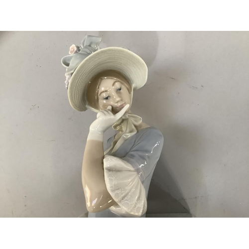 25 - A large Lladro figure of a young woman with a flower and ribboned bonnet and parasol, in pensive moo... 