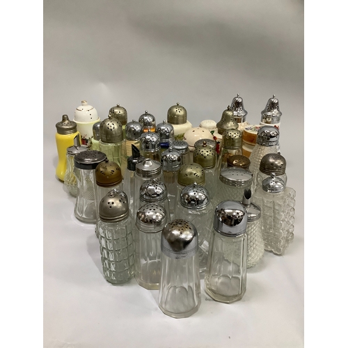 96 - A large collection of glass sugar sifters with silver plated and other tops