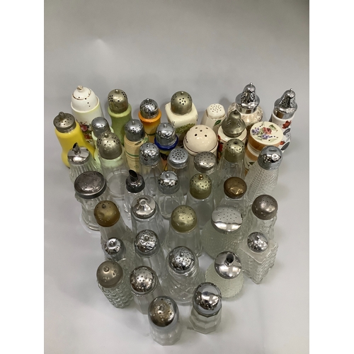 96 - A large collection of glass sugar sifters with silver plated and other tops