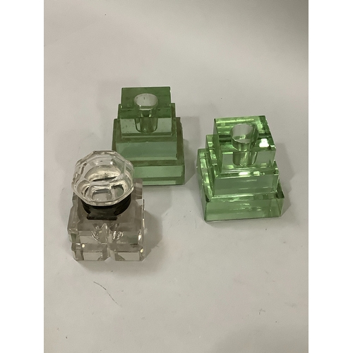 55 - A pair of green glass stepped inkwells together with another inkwell with silver plated mount