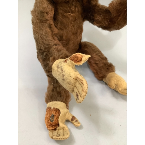 59 - A Steiff monkey with brown fur, pink face and paws, label to ear, worn condition