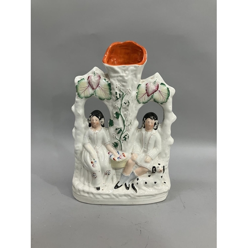 70 - A 19th century Staffordshire spill vase modelled with a male and female figure seated in an arbour, ... 