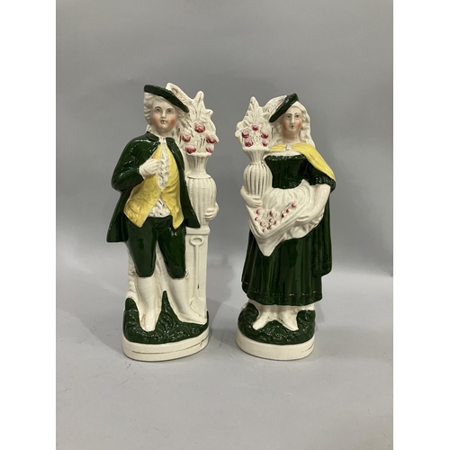 71 - A pair of late 19th/early 20th century Stafforshire gardening figures attired in green, the man with... 