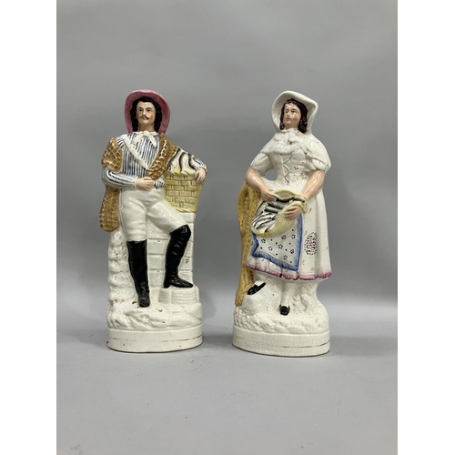 76 - A pair of 19th century Staffordshire figures of fisherman and wife with baskets of fish, 24cm high