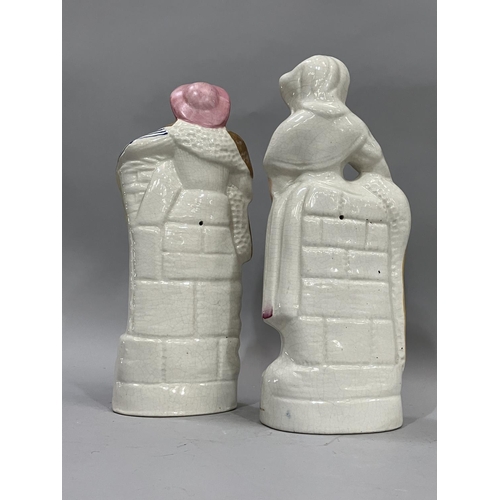 76 - A pair of 19th century Staffordshire figures of fisherman and wife with baskets of fish, 24cm high