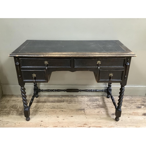 482 - A dark oak desk having a leather incised writing surface above two long and two short drawers flanke... 