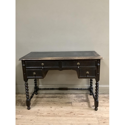 482 - A dark oak desk having a leather incised writing surface above two long and two short drawers flanke... 