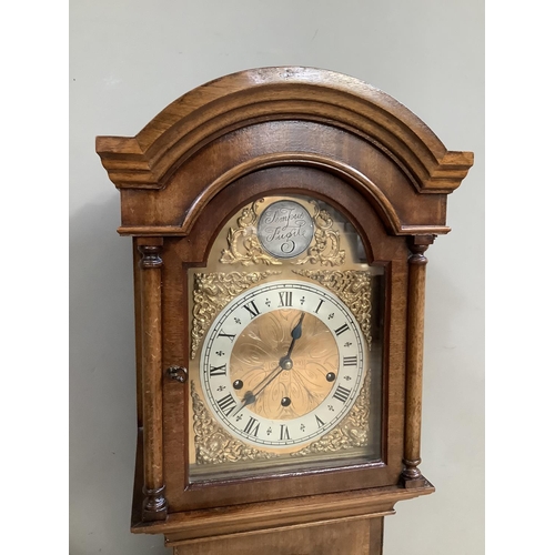 488B - A mahogany and walnut grandmother clock having an arched hood with pilasters, gilt dial with silvere... 