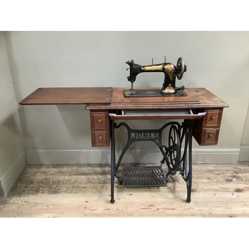 499 - A Jones sewing machine in table cabinet with small drawers, cast iron legs and treadle 86cm wide x 4... 