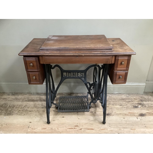 499 - A Jones sewing machine in table cabinet with small drawers, cast iron legs and treadle 86cm wide x 4... 