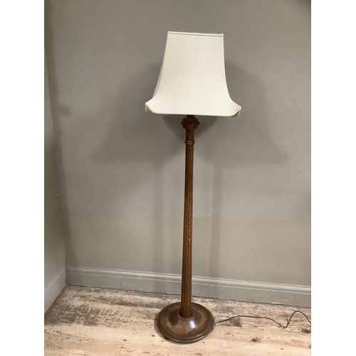 504 - A polished beech standard lamp with reeded column, on circular base with shade