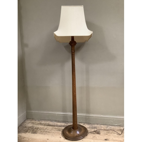 504 - A polished beech standard lamp with reeded column, on circular base with shade