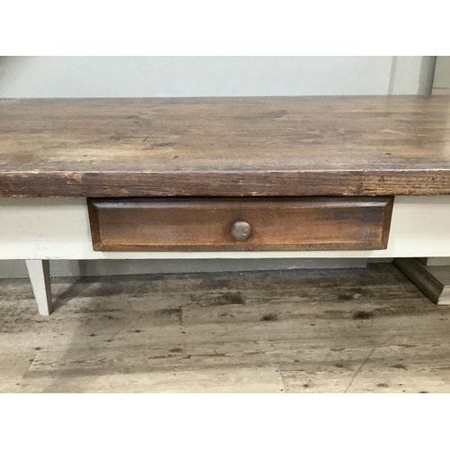 512 - A French farmhouse table having a fruitwood three plank surface with cleated ends and on four square... 