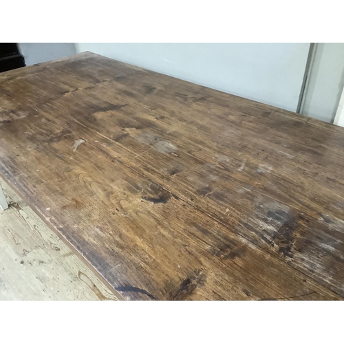 512 - A French farmhouse table having a fruitwood three plank surface with cleated ends and on four square... 