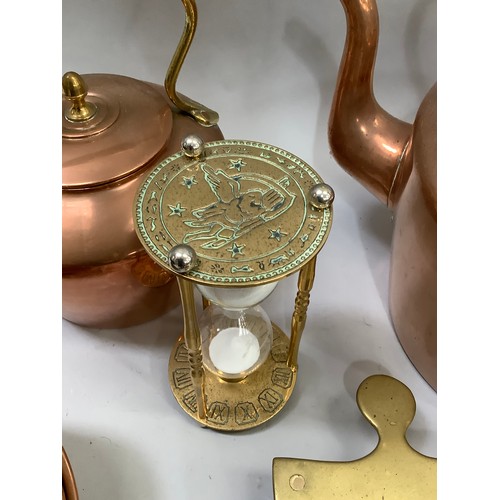 92 - A large collection of copperware comprising two kettles, copper moulds, brass trivet etc