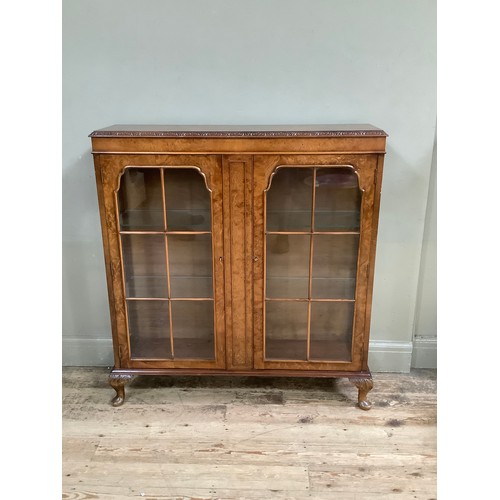 477 - A 1950's Art Deco walnut display cabinet, two doors on cabriole legs