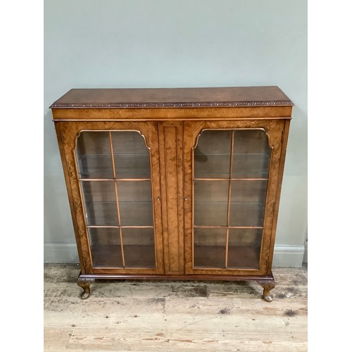 477 - A 1950's Art Deco walnut display cabinet, two doors on cabriole legs