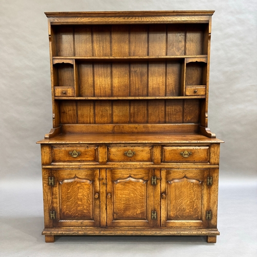 357 - An oak reproduction dresser and plate rack in the style of Titchmarsh and Goodwin, base having three... 