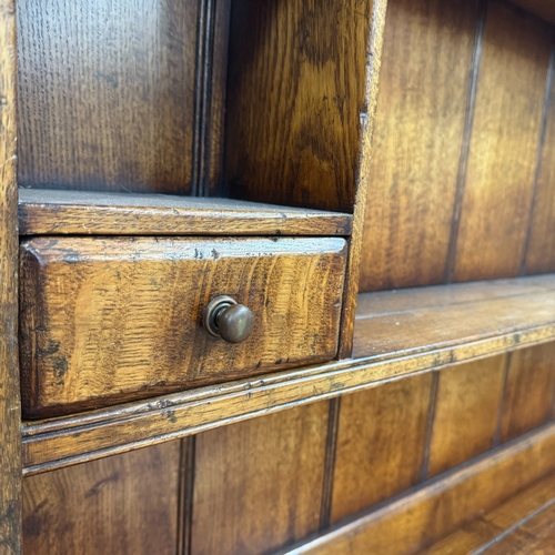 357 - An oak reproduction dresser and plate rack in the style of Titchmarsh and Goodwin, base having three... 