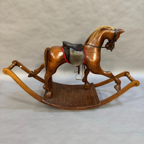 315 - A modern rocking horse with leather saddle, harness and reins, on planked rocking base, 190cm wide, ... 