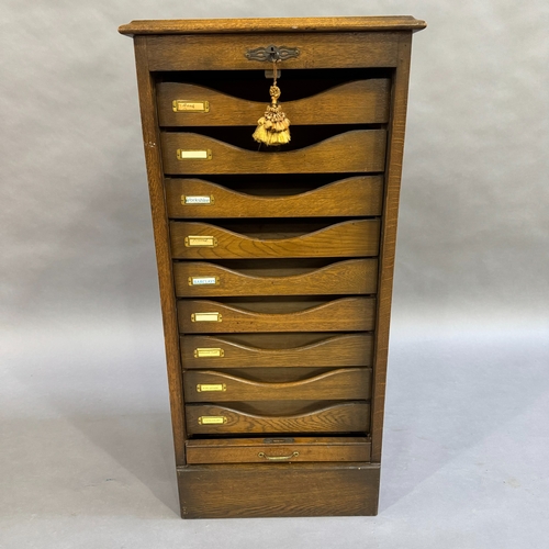 308 - A 1920's oak tambour fronted filing cabinet with nine trays, 48cm wide, 103cm high, 42cm deep