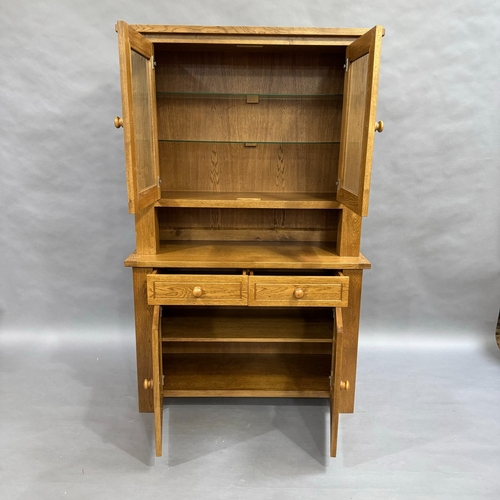 339 - A modern oak dresser, top comprising of two glazed doors opening to two glass shelves, base having t... 