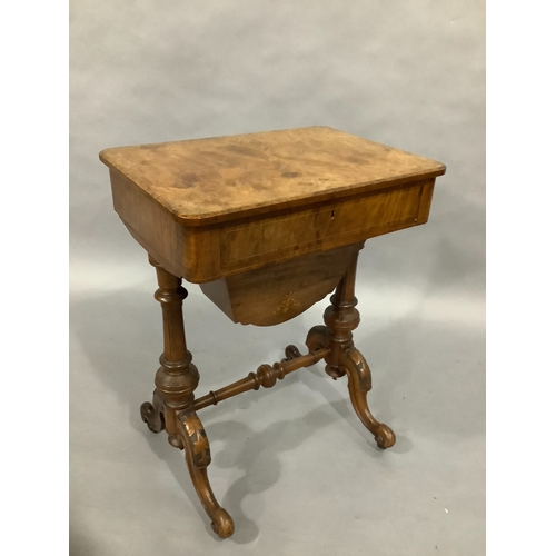 323 - A Victorian walnut sewing table on twin supports, cabriole carved legs, satinwood inlay with foliate... 