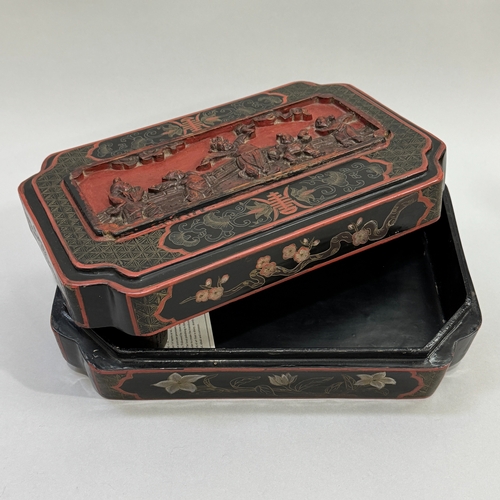 20 - A Japanese lacquered box of rectangular form with inwardly curving corners, the lid relief moulded w... 