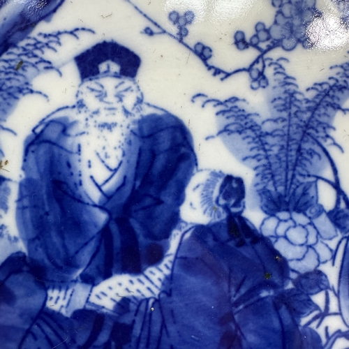 25 - A late 19th century Chinese blue and white charger decorated with dignitary and attendants in a gard... 