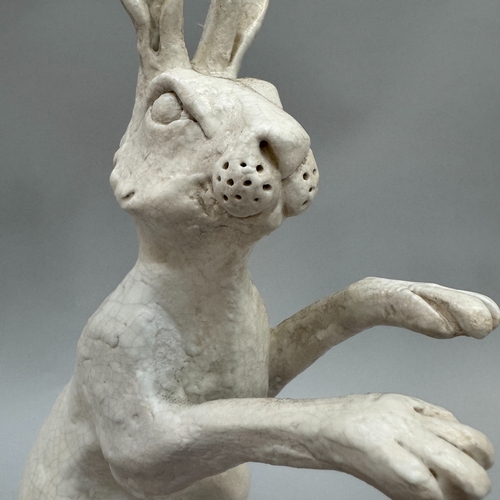 41 - A pair of studio pottery sculptures of hares by Alison Coaton, in off-white crackle glaze, artist's ... 