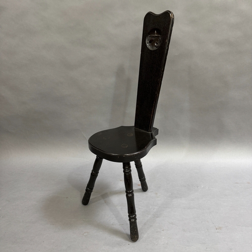 110 - A dark stained oak spinning chair, back carved with weighing scales, 90cm high