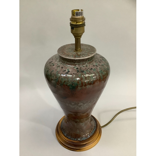 13 - A Cobridge stoneware table lamp of mottled deep turquoise and brown glaze, baluster form, on a wood ... 