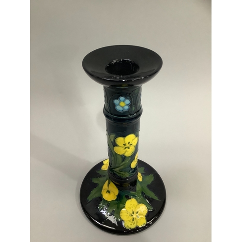 6 - A Moorcroft Buttercup pattern candlestick, tubelined and enamelled in shades of blue, green and yell... 