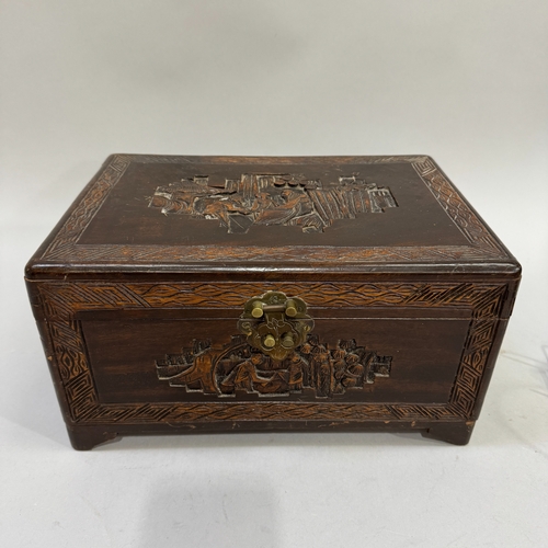 60 - A 1930s small Chinese camphor wood box, the lid and panels carved with figures in a garden landscape... 