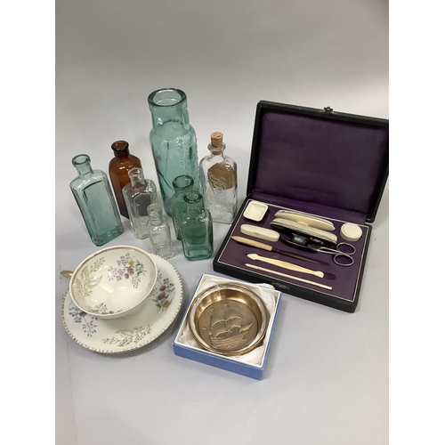 89 - A bone handled sewing set in case, several glass bottles, a continental cup and saucer and a commemo... 