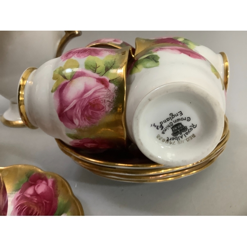 72 - A Royal Albert china tea service printed with roses in shades of pink, highlighted in gilt on a whit... 